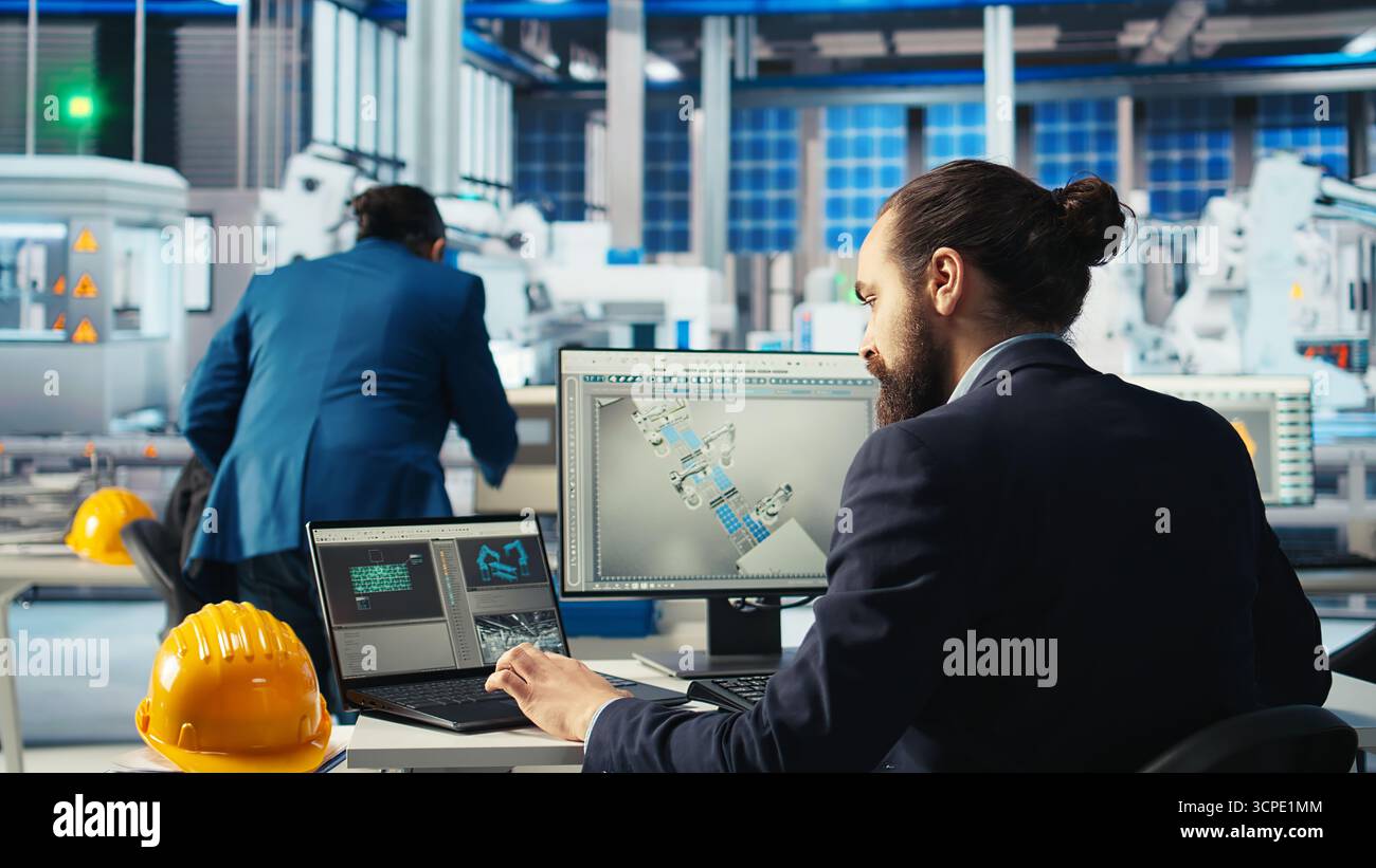 Le technicien d'usine photovoltaïque ajuste les paramètres du système sur l'ordinateur portable pour maximiser la production d'énergie des cellules solaires. Homme utilisant un ordinateur portable optimisant l'approvisionnement en énergie dans l'usine de fabrication de panneaux solaires, caméra A. Banque D'Images