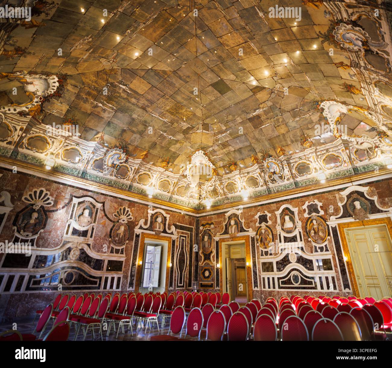 Intérieur de la Galerie des glaces de la Villa Palagonia, avec des décorations ornées et des rangées de chaises vides en velours rouge soigneusement arrangées pour des concerts ou p Banque D'Images Intérieur de la Galerie des glaces de la Villa Palagonia, avec des décorations ornées et des rangées de chaises vides en velours rouge soigneusement arrangées pour des concerts ou p Banque D'Images