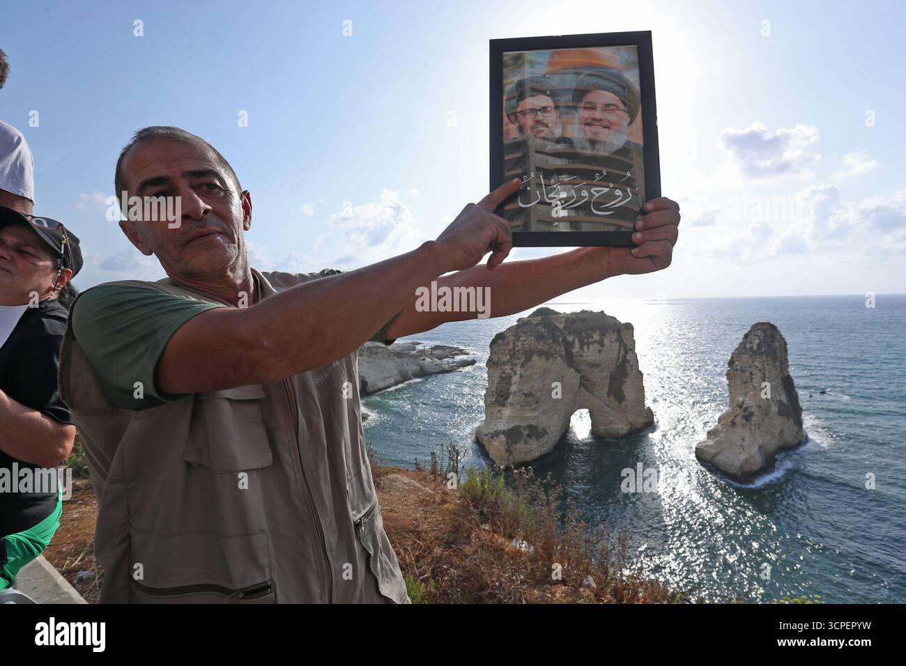 Beyrouth, Liban. 25 septembre 2025. Un partisan du Hezbollah tenant des portraits des anciens dirigeants du Hezbollah Hassan Nasrallah et Hashem Safieddine assiste à un rassemblement de masse dans la région de Raouche à Beyrouth, Liban, le 25 septembre 2025. Des centaines de partisans du Hezbollah se rassemblent jeudi sur le front de mer de Beyrouth pour commémorer les anciens dirigeants Hassan Nasrallah et Hashem Safieddine. Crédit : Bilal Jawich/Xinhua/Alamy Live News Banque D'Images