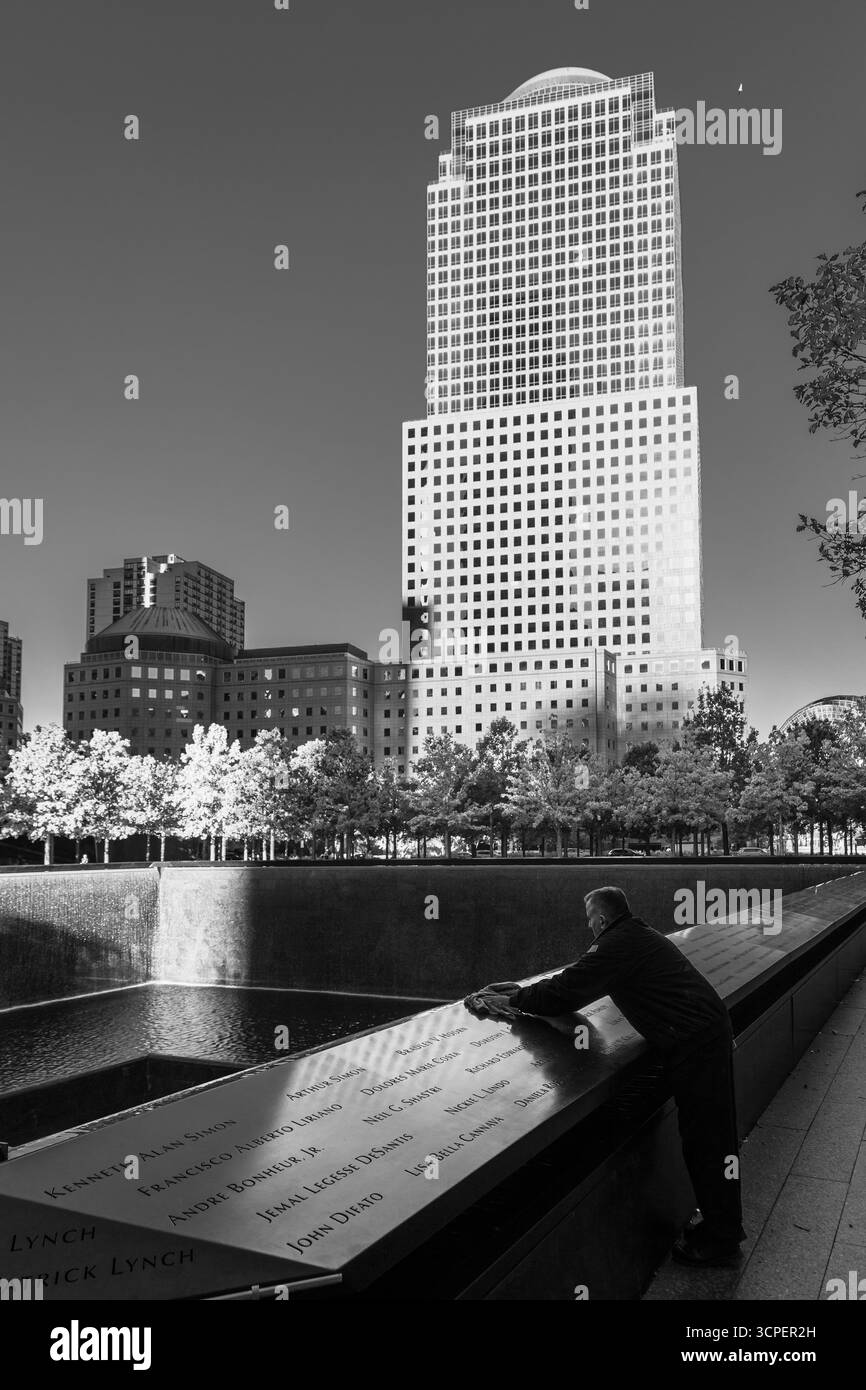 Homme nettoyant le marbre gravé du mémorial de 9-11, New York City, NY, États-Unis Banque D'Images