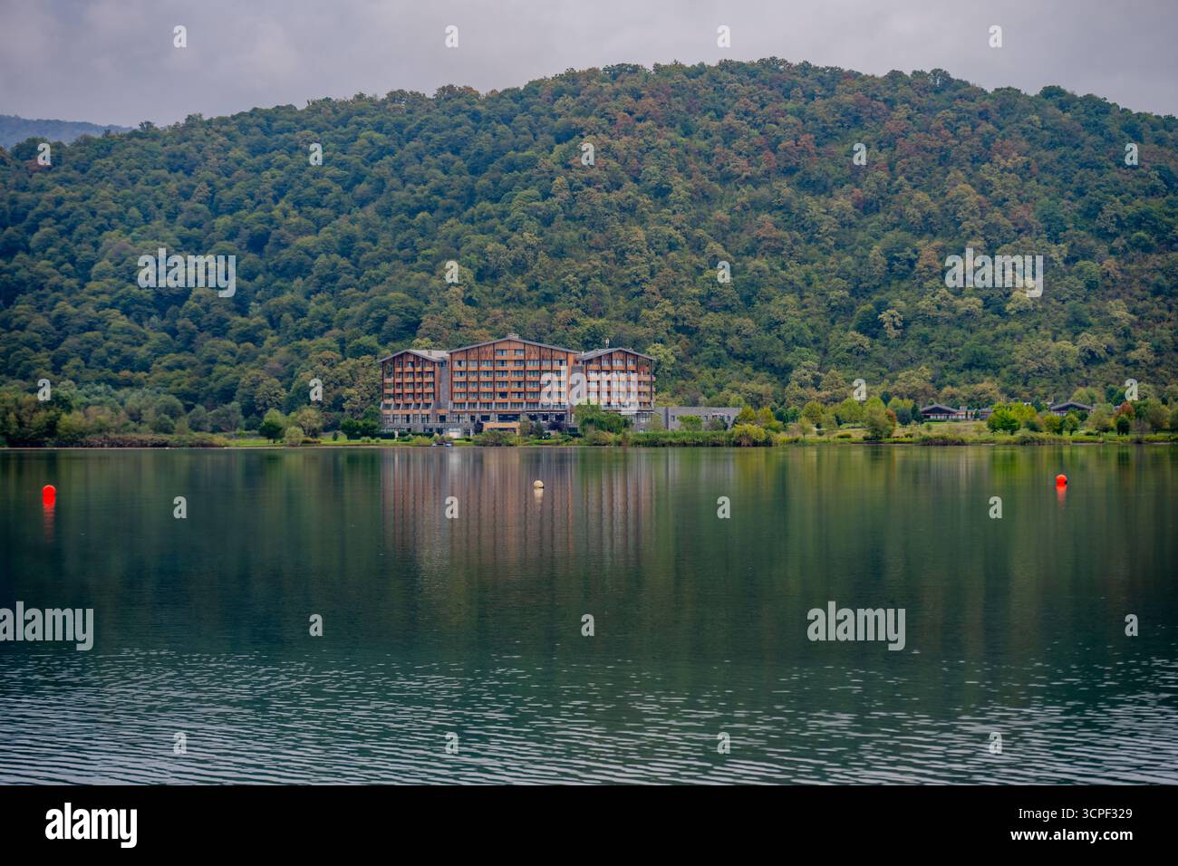 Une vue panoramique d'un hôtel au bord du lac reflétant les eaux calmes, entouré de montagnes boisées verdoyantes à Qabala, Azerbaïdjan. Qabala, Azerbaïdjan Banque D'Images