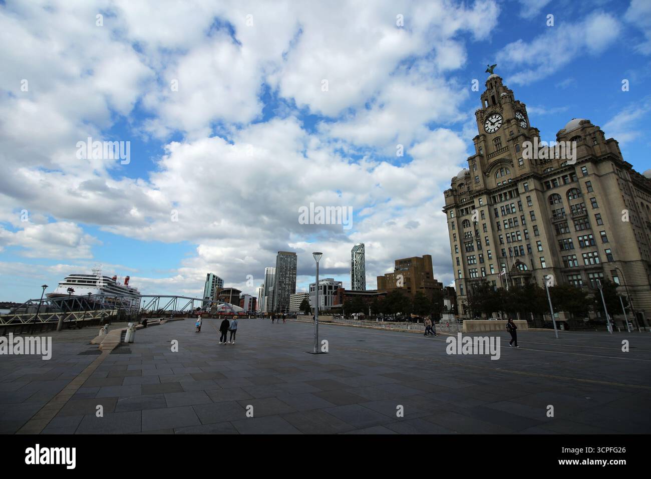 Le Royal Liver Building à Pier Head, Liverpool, contraste avec les gratte-ciel modernes et un bateau de croisière amarré sous un ciel bleu. Banque D'Images