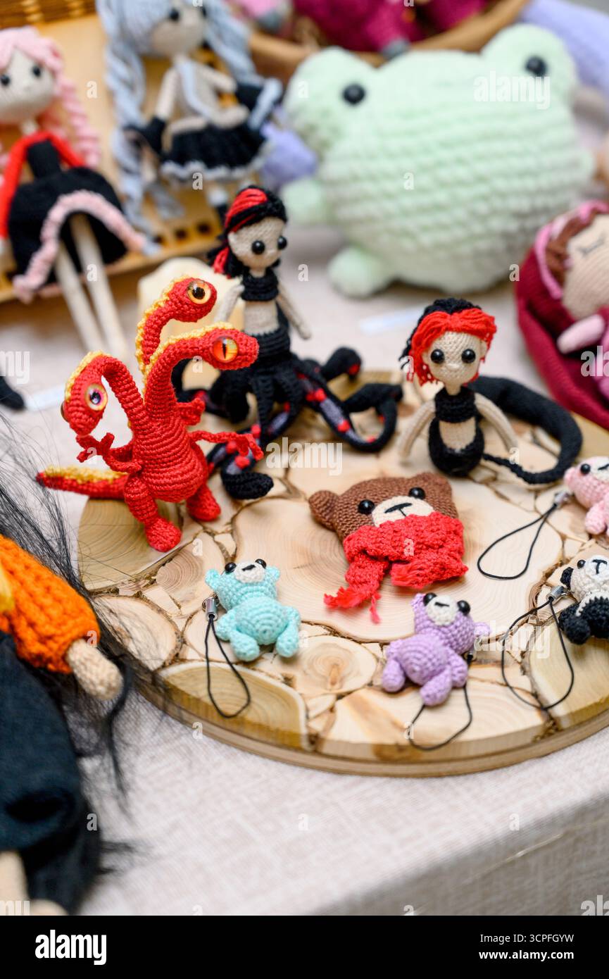 Un ensemble de jouets amigurumi crochetés sous la forme de personnages fictifs. Une collection de jouets tricotés sur un support en bois. Figurines miniatures faites à la main : a Banque D'Images