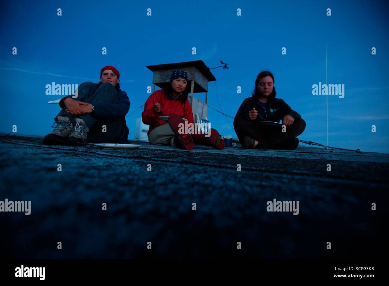 Les chercheurs du projet Puffin Liz Zinsser, Maki Briggs et Juliet Lambs dînent sur le toit de la cabane du projet Puffin sur Eastern Egg Rock Island, dans le Maine. Banque D'Images