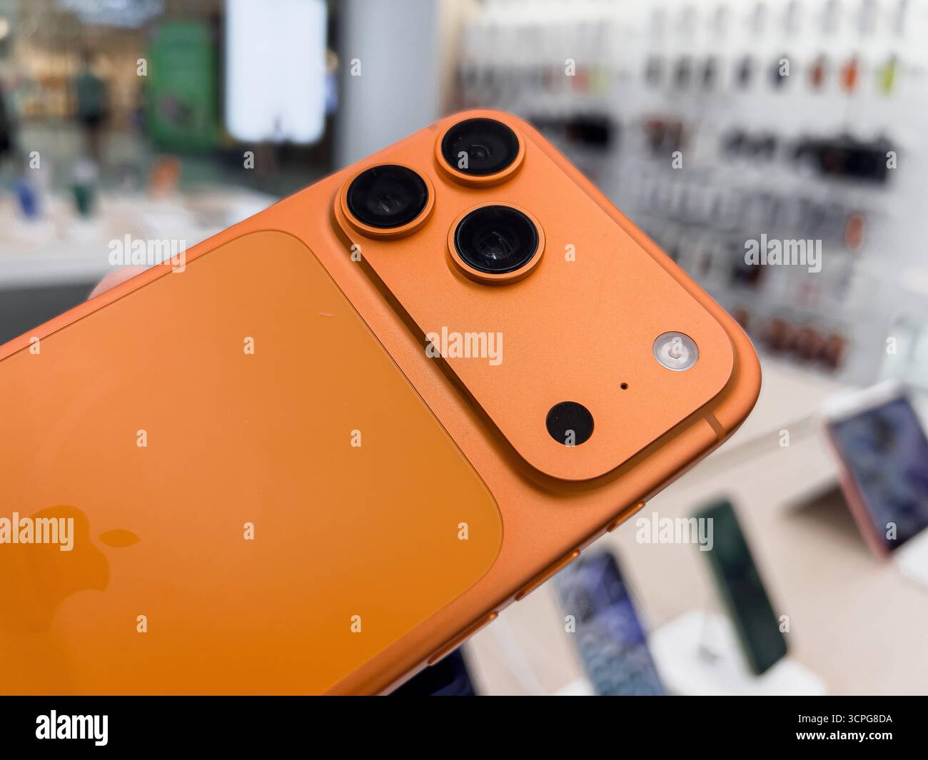 Poznan, Pologne - 20 septembre 2025 : iPhone 17 Pro, téléphone Apple orange vif, gros plan montrant triple caméra avancée, design élégant, logo, store dis Banque D'Images