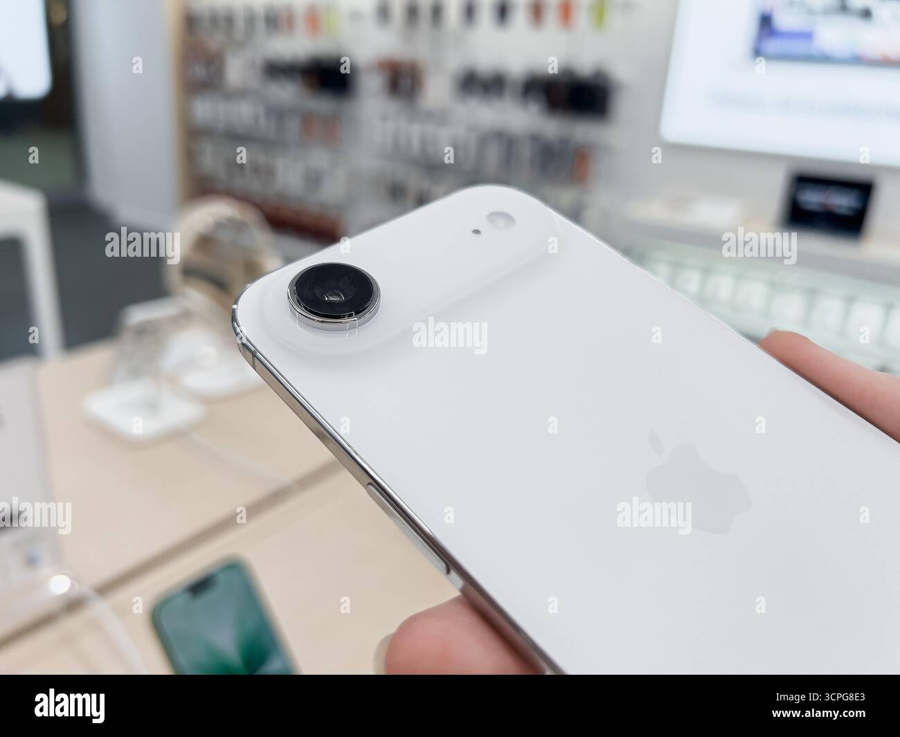 Poznan, Pologne - 20 septembre 2025 : iPhone Air, un nouveau smartphone blanc, tenu par la main d'un client, présente son unique appareil photo dans un el dynamique Banque D'Images