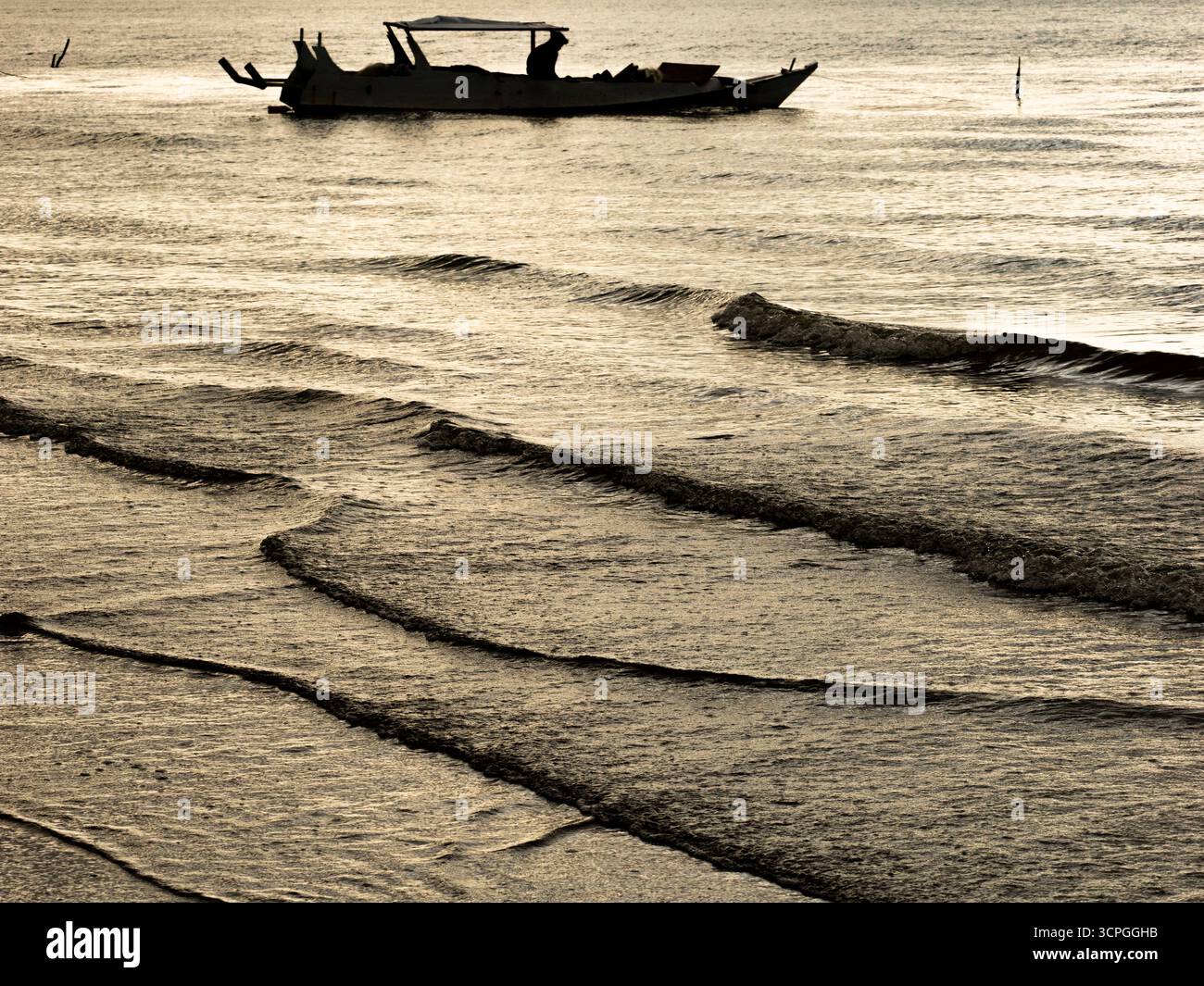 Silhouette de bateau et de vagues, près de Sudamala Resort, Flores, Indonésie Banque D'Images