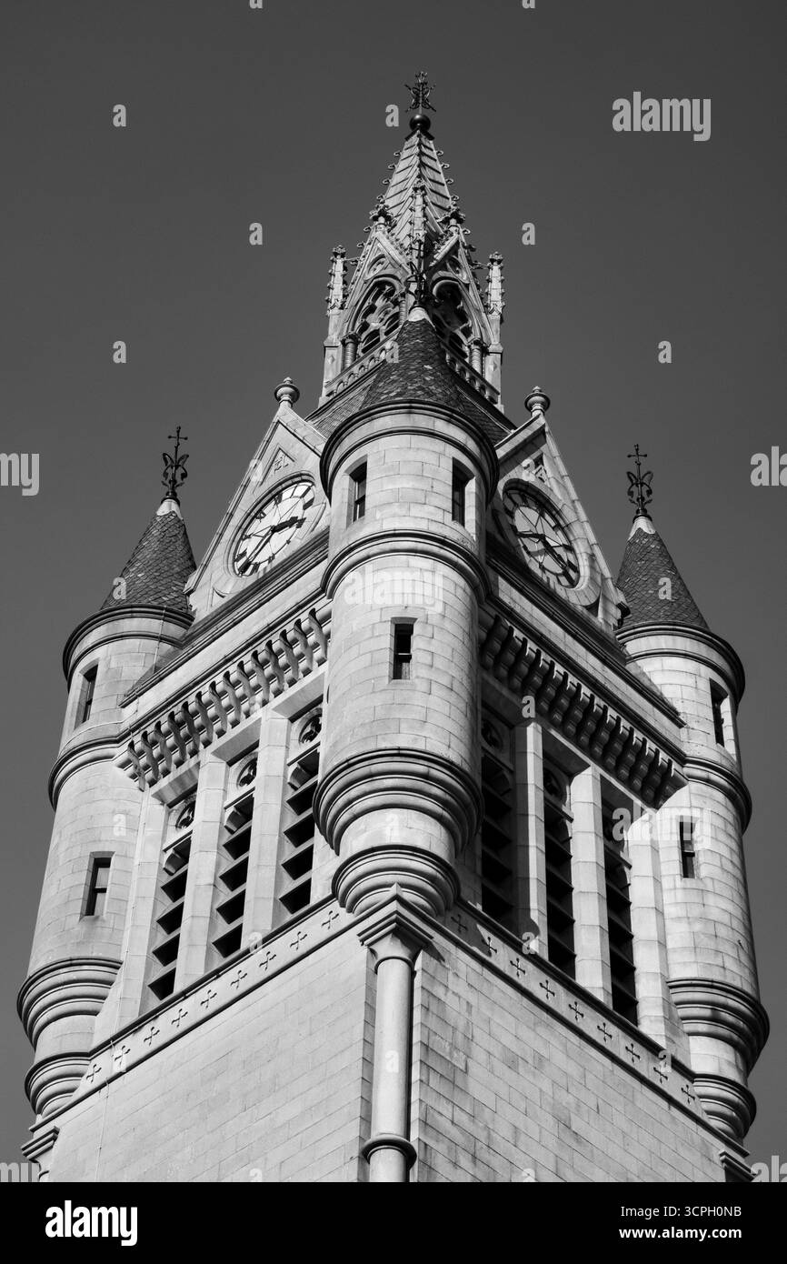 Un cliché spectaculaire en noir et blanc, en bas angle, d'une imposante tour de l'horloge ornée de flèches et de détails architecturaux complexes. Banque D'Images