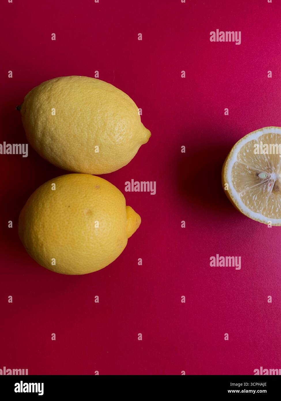 Motif de citron frais sur un fond rose vif. Pose à plat. Citrons. Vitamine C. créatif minimal Concept estival minimal. Citron entier et coupé en deux. - Image de stock capturée avec un smartphone