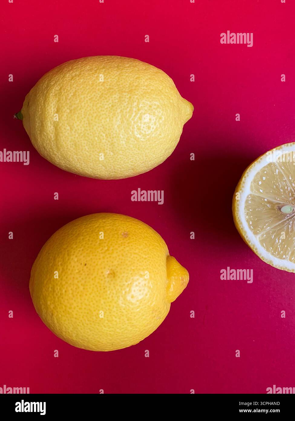 Motif de citron frais sur un fond rose vif. Pose à plat. Citrons. Vitamine C. créatif minimal Concept estival minimal. Citron entier et coupé en deux. - Image de stock capturée avec un smartphone