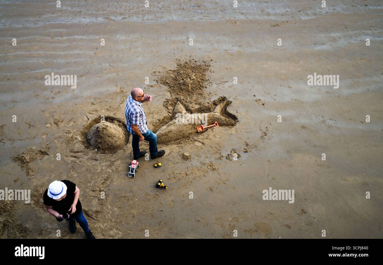 Des gens adultes avec des jouets pour enfants sur une plage Banque D'Images