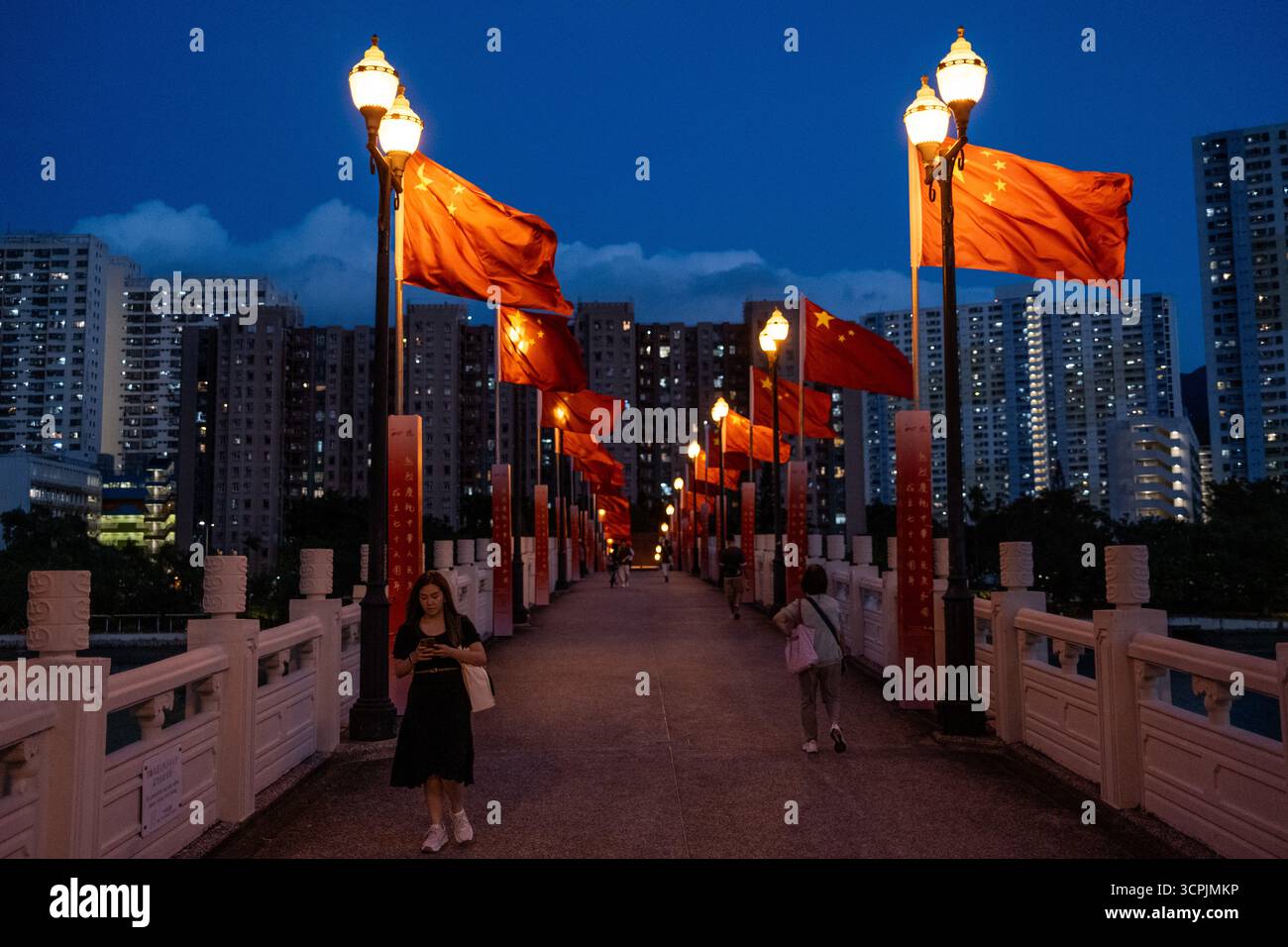 Hong Kong, Hong Kong. 26 septembre 2025. Des gens marchant sur un pont avec des drapeaux nationaux chinois sur elle au-dessus de la rivière Shing Mun dans le district de Sha Tin le 26 septembre 2025 à Hong Kong. (Crédit image : © Vernon Yuen/Nexpher images via ZUMA Press Wire) USAGE ÉDITORIAL SEULEMENT ! Non destiné à UN USAGE commercial ! Banque D'Images