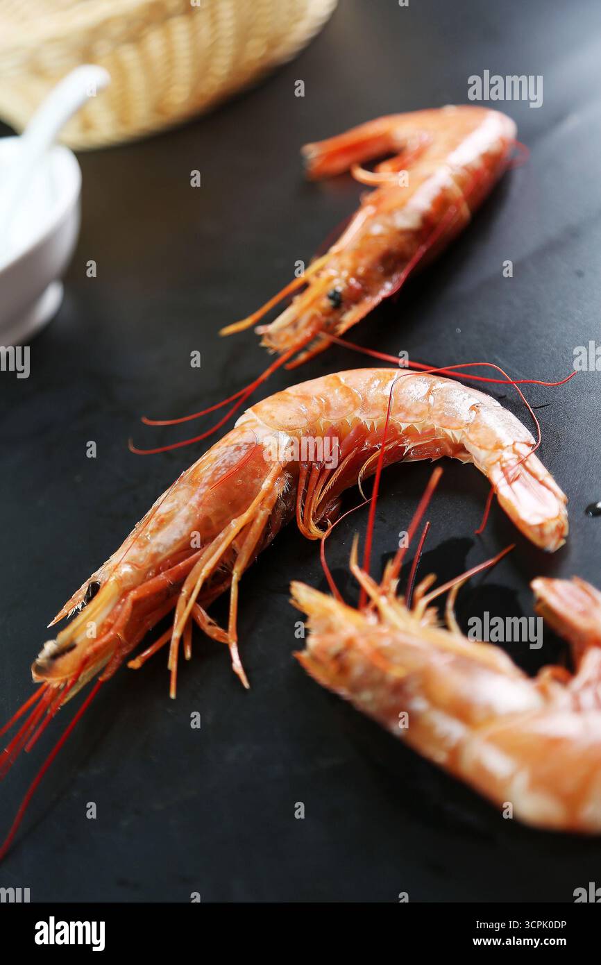 Crevettes rouges argentines cuites (Pleoticus muelleri) sur table sombre Banque D'Images