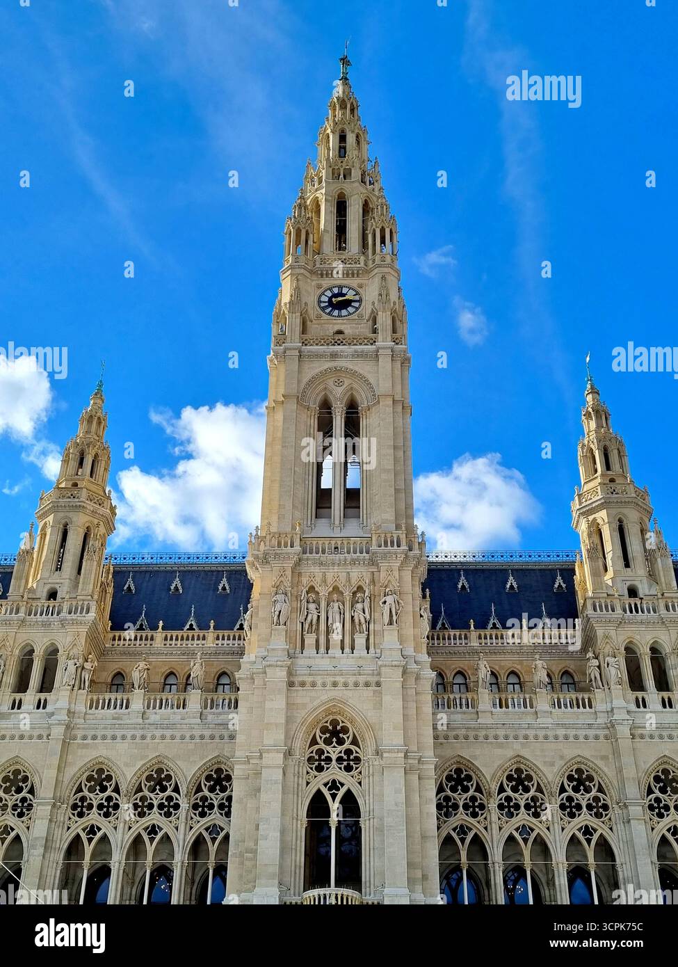 Une vue de la façade en dentelle ensoleillée de l'hôtel de ville et de la tour de l'horloge contre un ciel bleu vif à Vienne, Autriche Banque D'Images