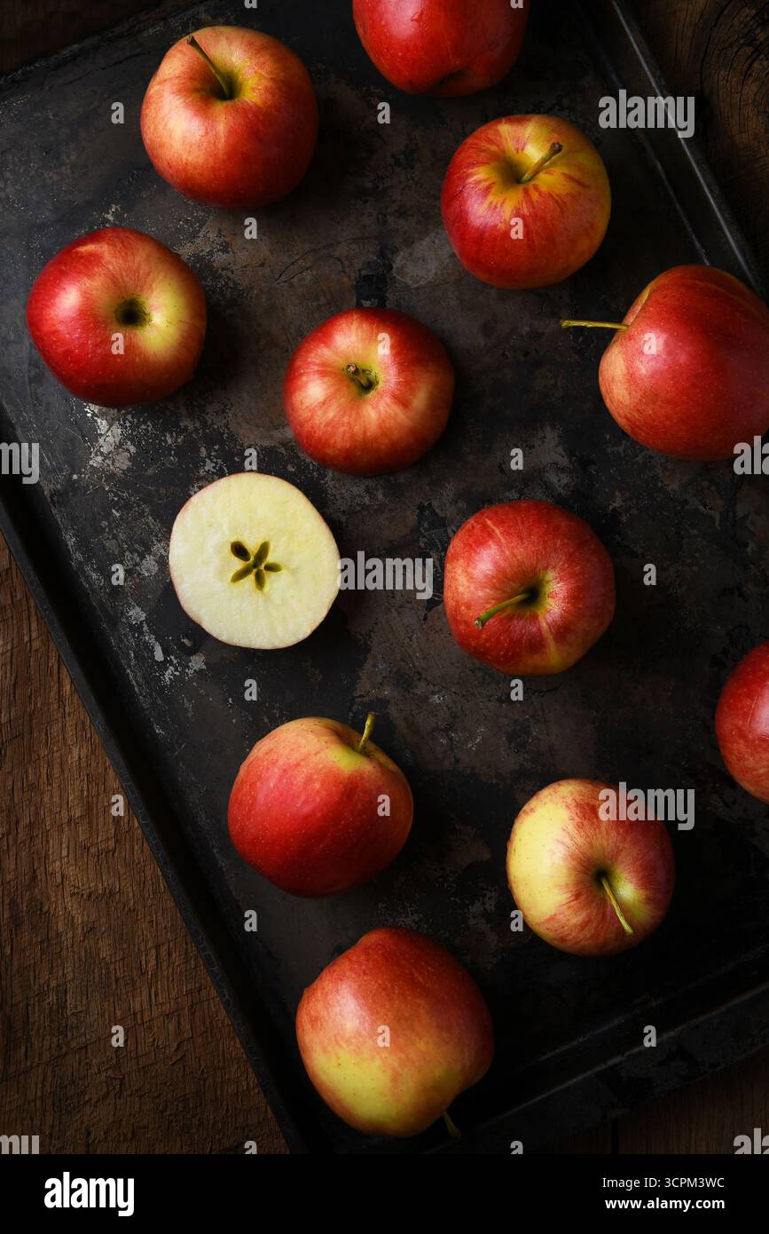 Pommes de gala. Higha angle suspendu plan d'un groupe de pommes une plaque à pâtisserie avec une pomme coupée en deux. Banque D'Images