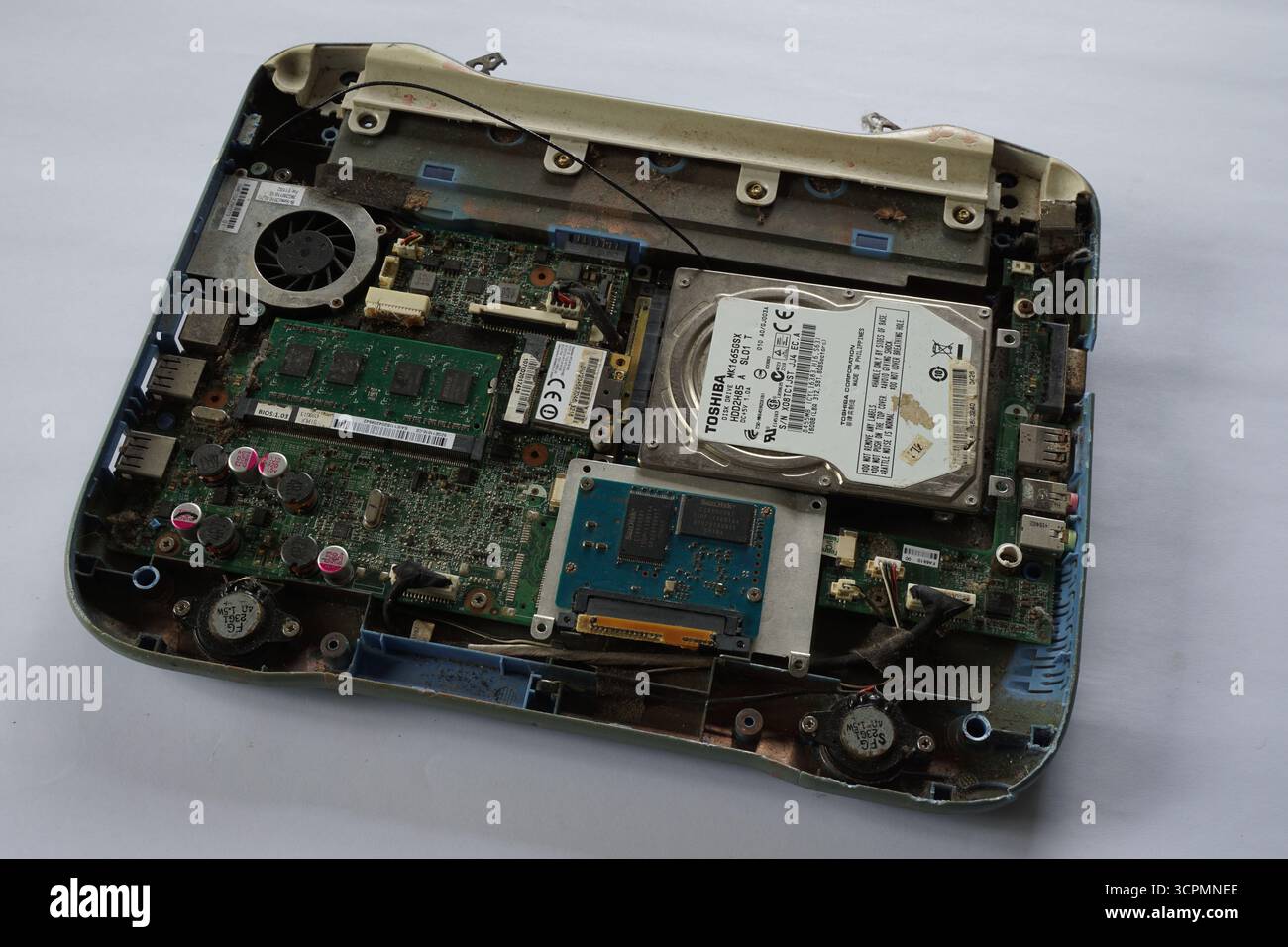 Démontage du vieil ordinateur portable sur fond blanc. Composant d'ordinateur portable tel que disque dur, mémoire, RAM, chipset, batterie, carte mère et autres. Banque D'Images