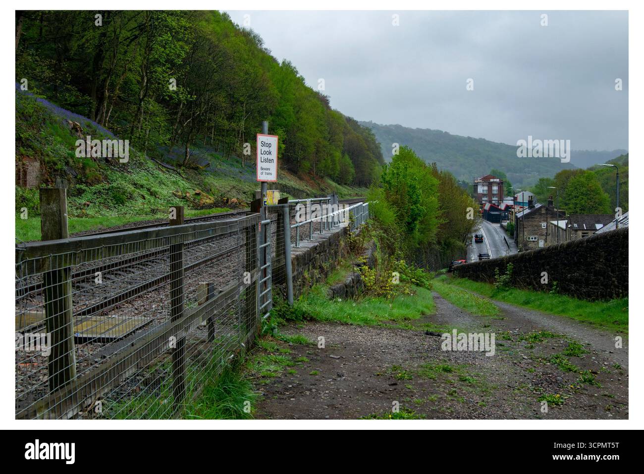 Le panneau « Stop look Listen » délavé garde les voies du site abandonné de la gare ferroviaire d'Eastwood, surplombant un village dans une vallée verdoyante. Banque D'Images