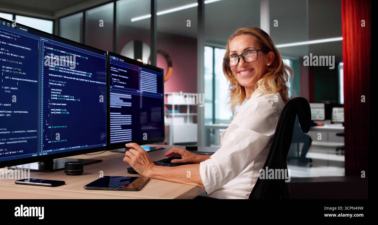 Codage de programmeur féminin sur plusieurs écrans d'ordinateur, Portrait innovant heureux Banque D'Images