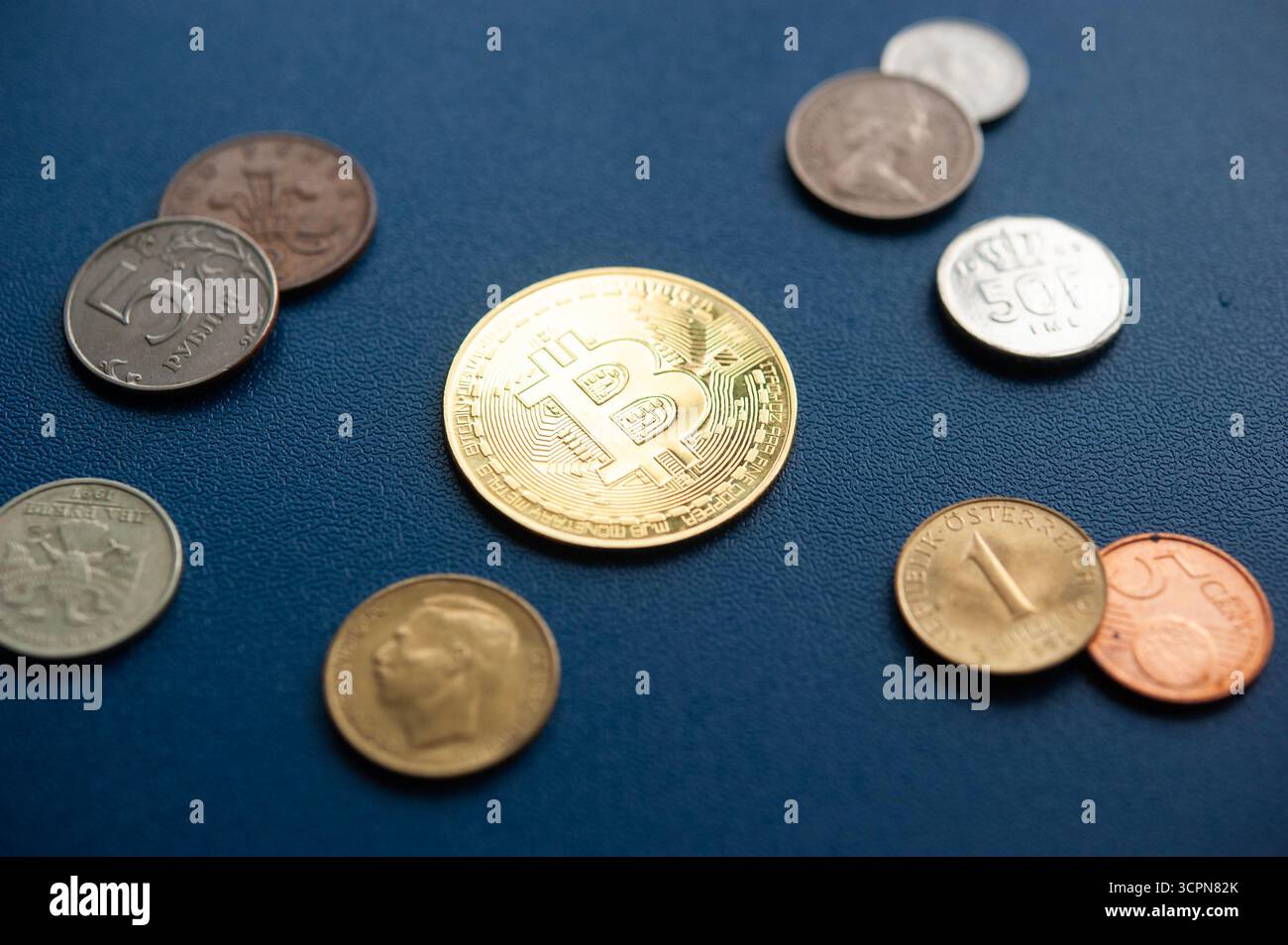 Coin de crypto-monnaie Bitcoin entouré de pièces mondiales traditionnelles représentant de l'argent numérique et physique Banque D'Images