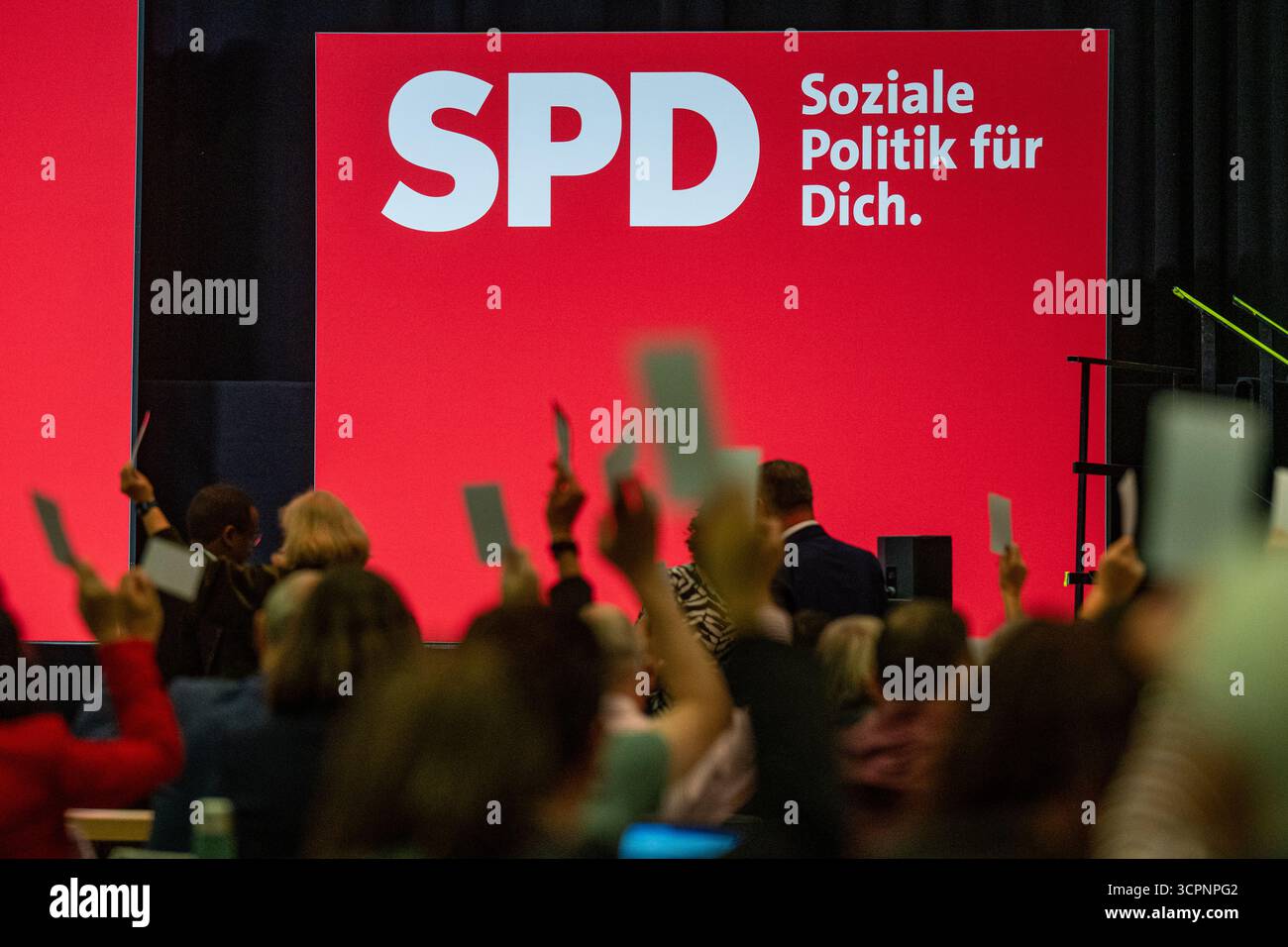 Landshut, Allemagne. 27 septembre 2025. Les délégués lèvent leur bulletin de vote devant le logo du SPD lors de la conférence du parti d'État du SPD bavarois. Crédit : Armin Weigel/dpa/Alamy Live News Banque D'Images
