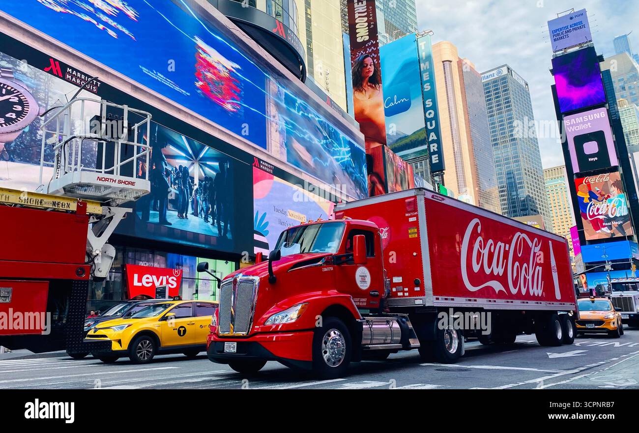 Camion Coca-Cola conduisant à travers Times Square avec Billboards lumineux et la vie urbaine - Image de stock capturée avec un smartphone