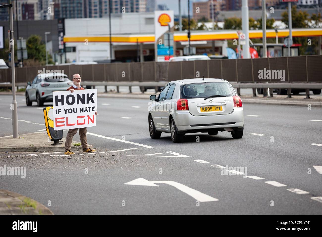 LONDRES, Royaume-Uni - 27 septembre 2025 : des activistes du groupe de campagne Tesla Takedown manifestent devant le showroom Tesla dans l'ouest de Londres, près de la gare Park Royal. Les manifestants portaient des pancartes et des banderoles contre Elon Musk, condamnant son récent discours vidéo à la marche d’extrême droite Unite the Kingdom à Londres, ses liens avec Donald Trump, et un nouvel accord du gouvernement américain pour déployer son chatbot Grok. Les militants ont accusé Musk d'alimenter les mouvements d'extrême droite et anti-immigrés. Banque D'Images