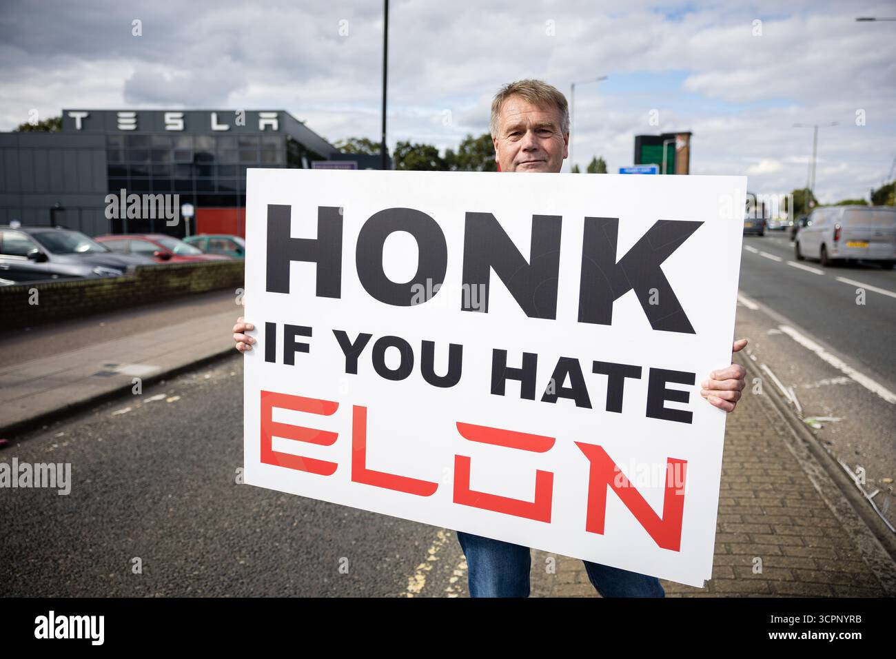 LONDRES, Royaume-Uni - 27 septembre 2025 : des activistes du groupe de campagne Tesla Takedown manifestent devant le showroom Tesla dans l'ouest de Londres, près de la gare Park Royal. Les manifestants portaient des pancartes et des banderoles contre Elon Musk, condamnant son récent discours vidéo à la marche d’extrême droite Unite the Kingdom à Londres, ses liens avec Donald Trump, et un nouvel accord du gouvernement américain pour déployer son chatbot Grok. Les militants ont accusé Musk d'alimenter les mouvements d'extrême droite et anti-immigrés. Banque D'Images