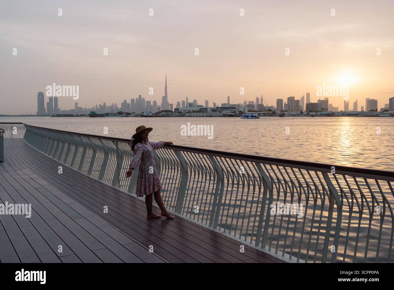 Promenades en soirée sur la promenade du front de mer avec yacht et skyline de Dubaï en arrière-plan, au coucher du soleil, monument paisible de Dubaï Banque D'Images