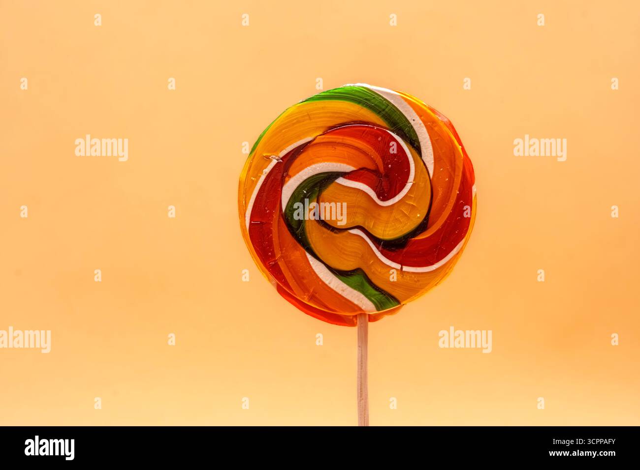 Sucette tourbillon aux couleurs vives sur fond jaune. Cette image ludique capture l'essence de la douceur de l'enfance avec sucette. Banque D'Images