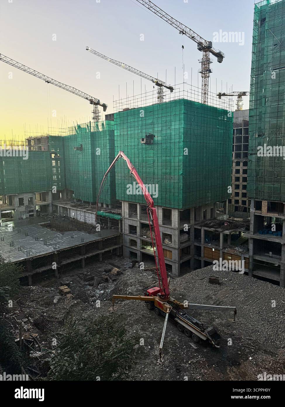 Camion-pompe à béton coulant du béton sur un chantier de construction. Travaux de construction sur un immeuble résidentiel multi-appartements. Banque D'Images
