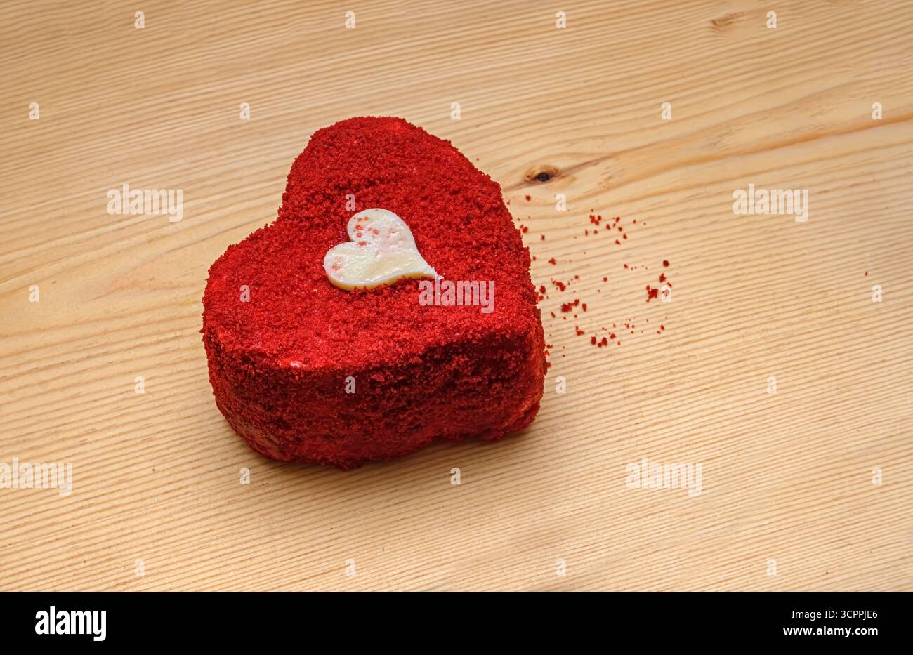 Dessert romantique sur la surface en bois. Un gâteau en forme de coeur avec une petite décoration de coeur en chocolat blanc est présenté. Concept de la Saint-Valentin phtp. Banque D'Images