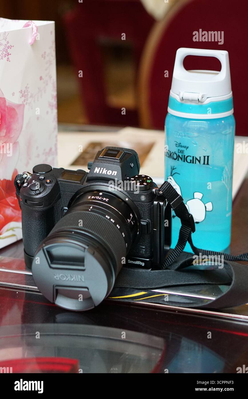 Appareil photo reflex numérique Nikon avec objectif sur la table à côté de Blue Disney bouteille et sac cadeau décoratif. Budapest, Hongrie Banque D'Images