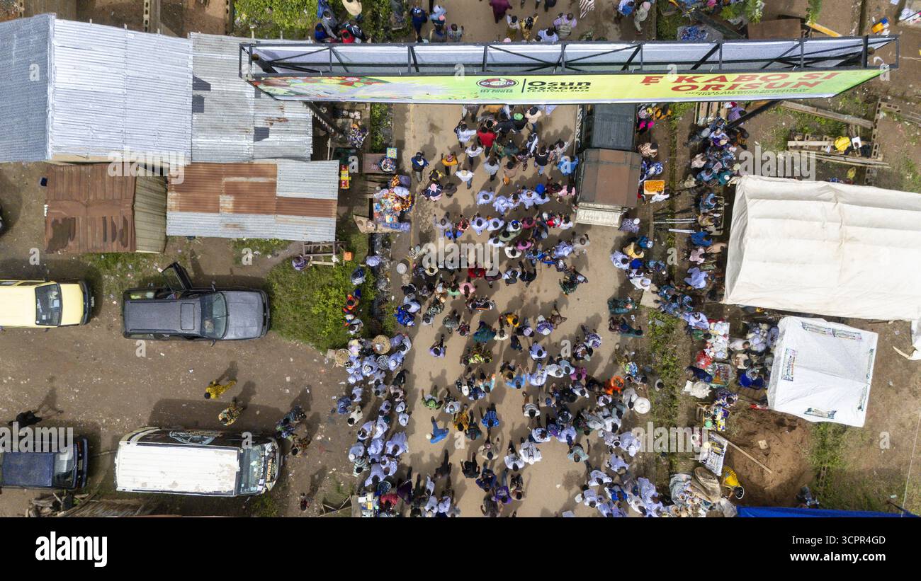 Vue aérienne des foules rassemblées près de l'entrée du bosquet sacré d'Osun-Osogbo, entouré de véhicules et de bâtiments, Osogbo, Osun, Nigeria. Banque D'Images
