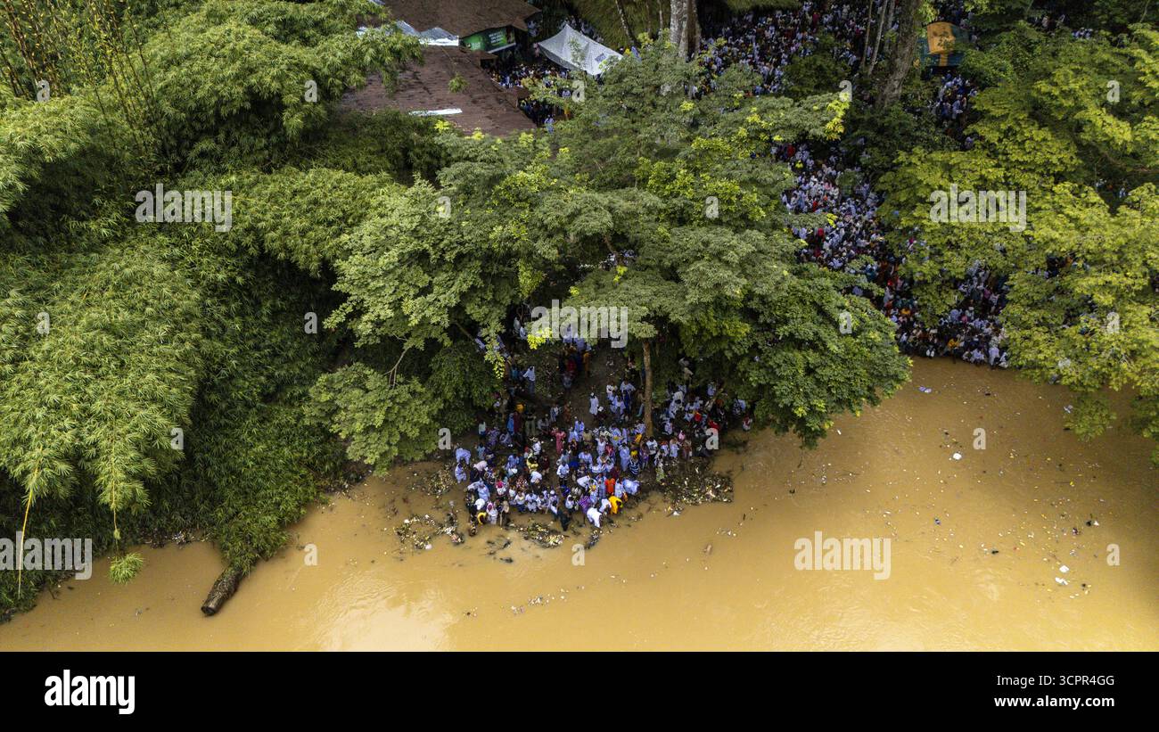 Vue aérienne de foules se rassemblant près de la rive boueuse adjacente à la dense et verdoyante bosquet sacrée d'Osun-Osogbo, Osogbo, Osun, Nigeria. Banque D'Images