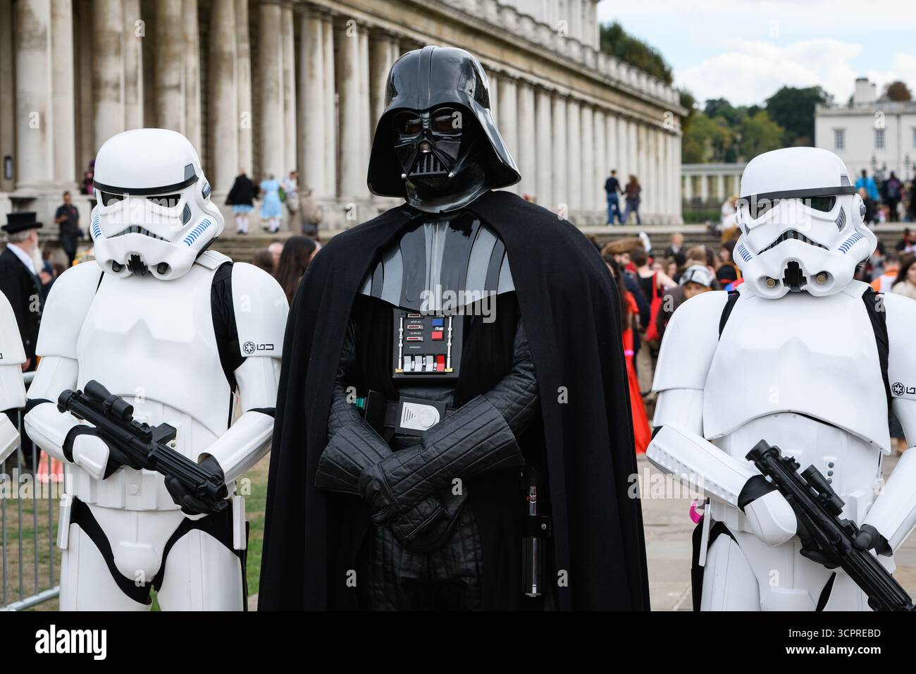 Londres, Royaume-Uni. 27 septembre 2025. Darth Vader de Star Wars est accompagné de Stormtroopers alors que les fans de cinéma établissent un record officiel du monde Guinness, avec 874 personnes déguisées en personnages de cinéma ou de télévision rassemblées à l'Old Royal Naval College, qui fait partie du site maritime Greenwich classé au patrimoine mondial de l'UNESCO. Organisé conjointement avec Elstree Studios, dans le cadre d'une célébration conjointe des 100 ans du film, les participants se sont habillés comme des personnages apparaissant dans des productions filmées à l'Old Royal Naval College ou aux studios Elstree. Crédit : Ron Fassbender/Alamy Live News Banque D'Images