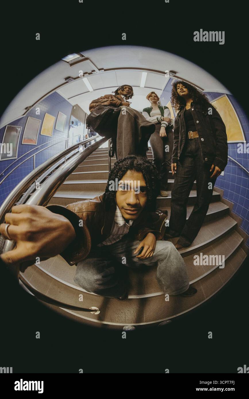 Fish Eye Lens portrait d'un groupe multiracial de jeunes amis posant sur les marches dans le métro Banque D'Images