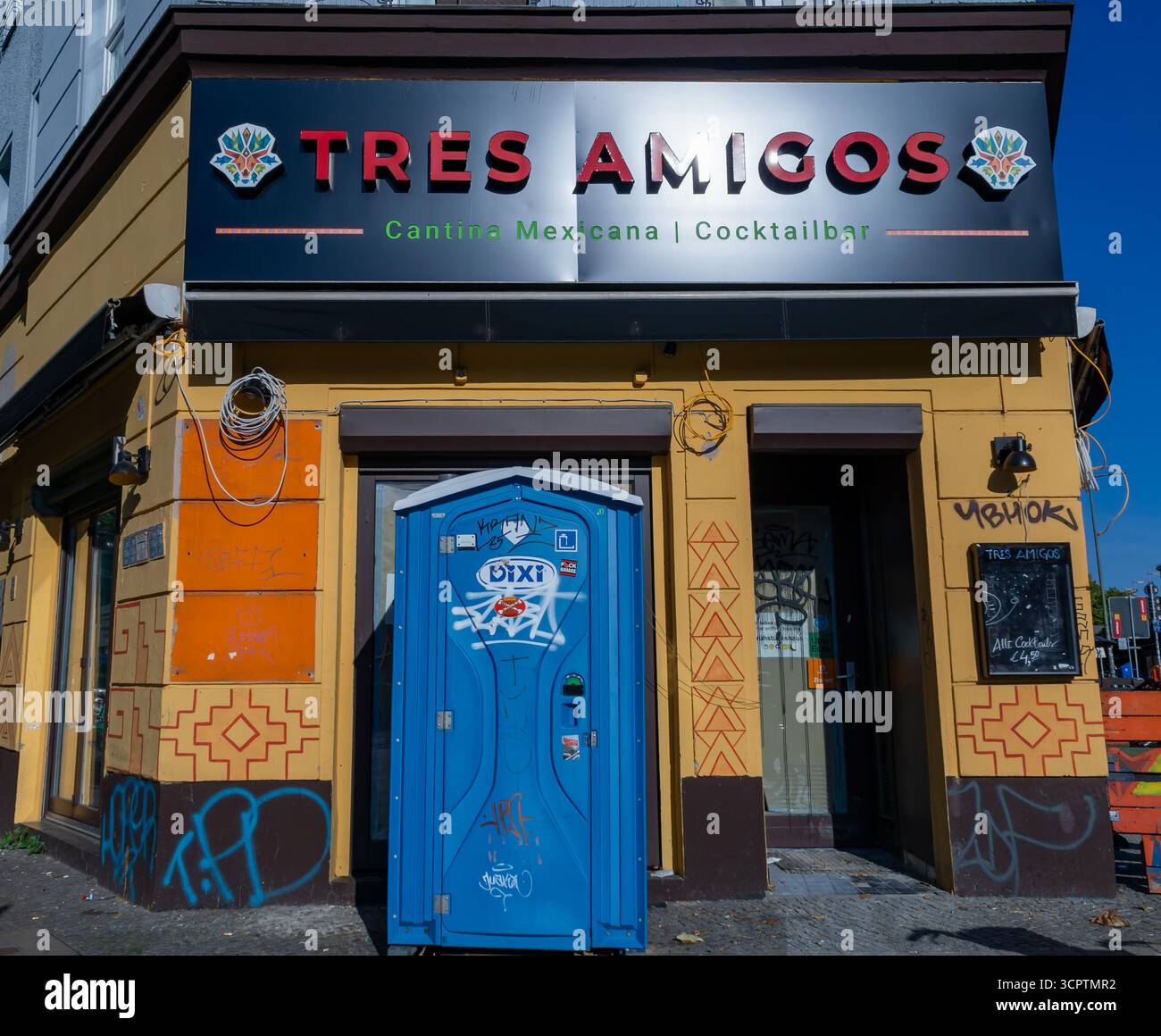 Restaurant mexicain avec volets à Berlin Kreuzberg avec toilettes portatives couvertes de graffitis placées directement devant l'entrée Banque D'Images