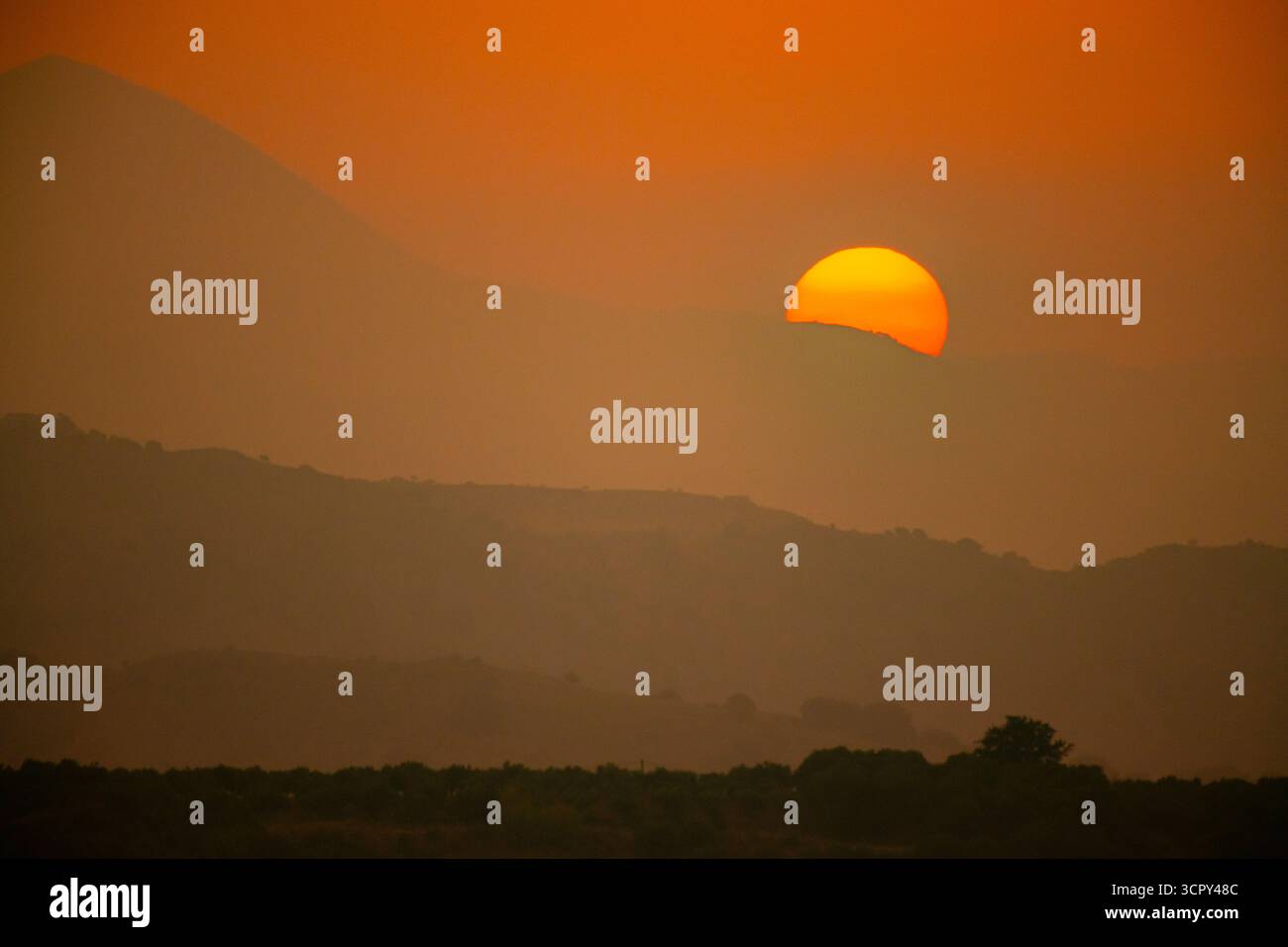 Le soleil se couche sur une chaîne de montagnes dans l'île grecque de Crète. Banque D'Images