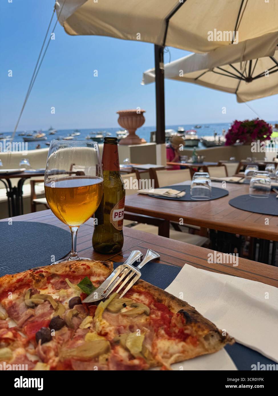 Pizza italienne et bière avec vue sur la mer pendant les vacances d'été Banque D'Images