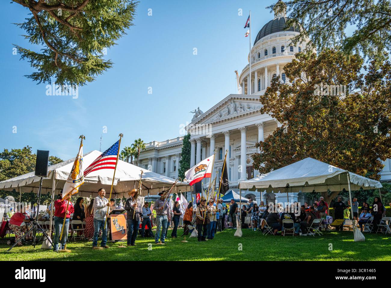 Des porteurs de drapeaux et de plumes d'aigle se tiennent au début du programme lors de l'événement annuel California Native American Day au Capitole de l'État. Banque D'Images