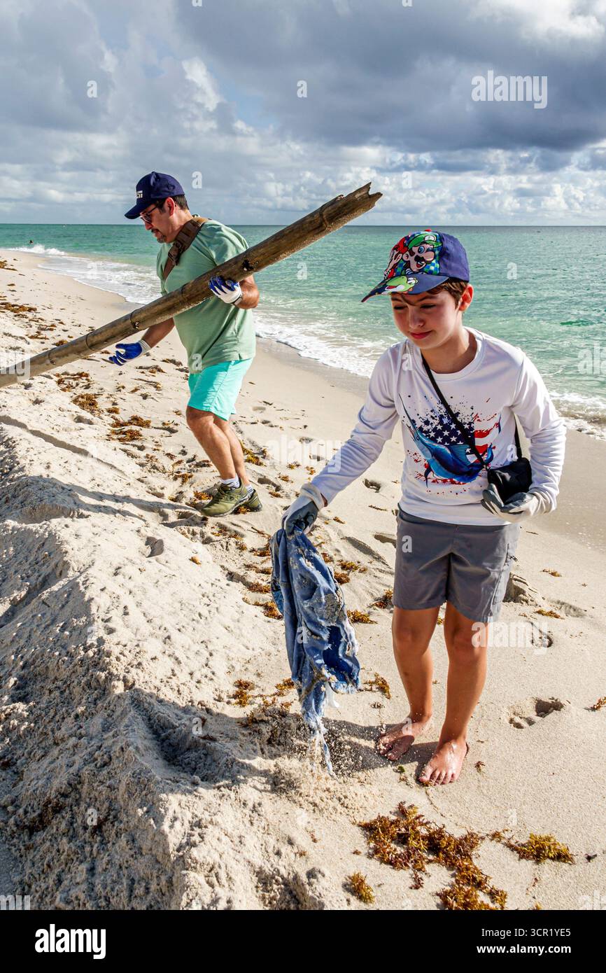 Miami Beach Floride, eau du rivage de l'océan Atlantique, événement mondial International Coastal Cleanup, père et fils bénévoles, garçon portant casquette, cueillette Banque D'Images