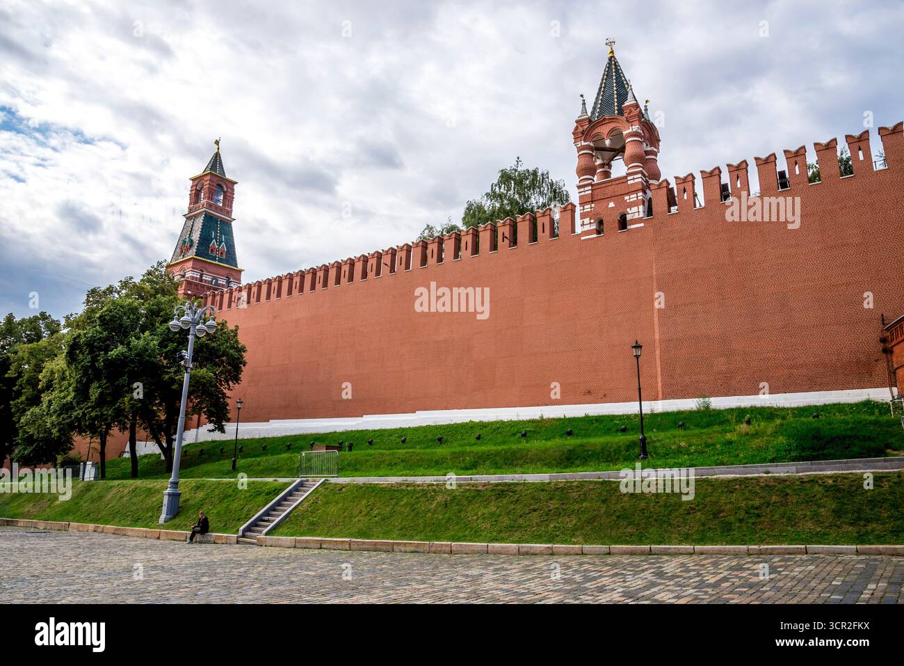 Mur du Kremlin en briques rouges avec Tour du tsar et Tour du clocher d'alarme sous un ciel nuageux, Moscou, Russie, 9 août 2025 Banque D'Images