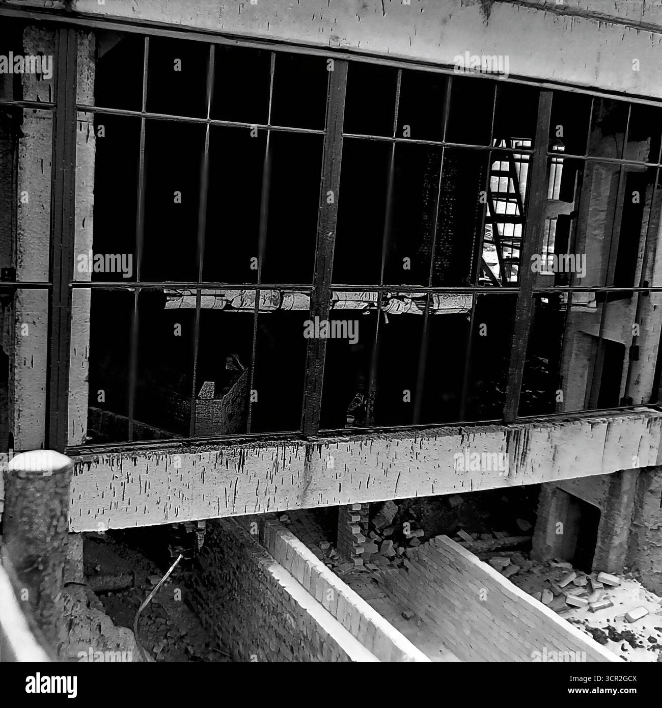 Vue rapprochée d’une grande fenêtre non vitrée ouvrant sur la façade d’un nouveau bâtiment industriel en construction à Sloviansk, RSS d’Ukraine, vers 1985. Cette photographie détaillée en noir et blanc met en valeur les textures brutes de l’architecture brutaliste, des surfaces en béton brut aux briques inachevées ci-dessous, capturant une étape intermédiaire du processus de construction et symbolisant le travail fondamental et constructif qui a défini la paisible région du Donbass Banque D'Images
