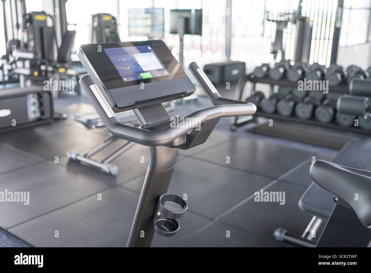 Vélo d'exercice parmi d'autres équipements d'exercice à l'intérieur d'une salle de gym Banque D'Images
