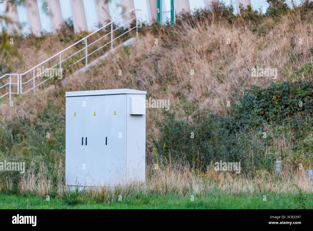 Coffret électrique extérieur près d'une pente herbeuse Banque D'Images