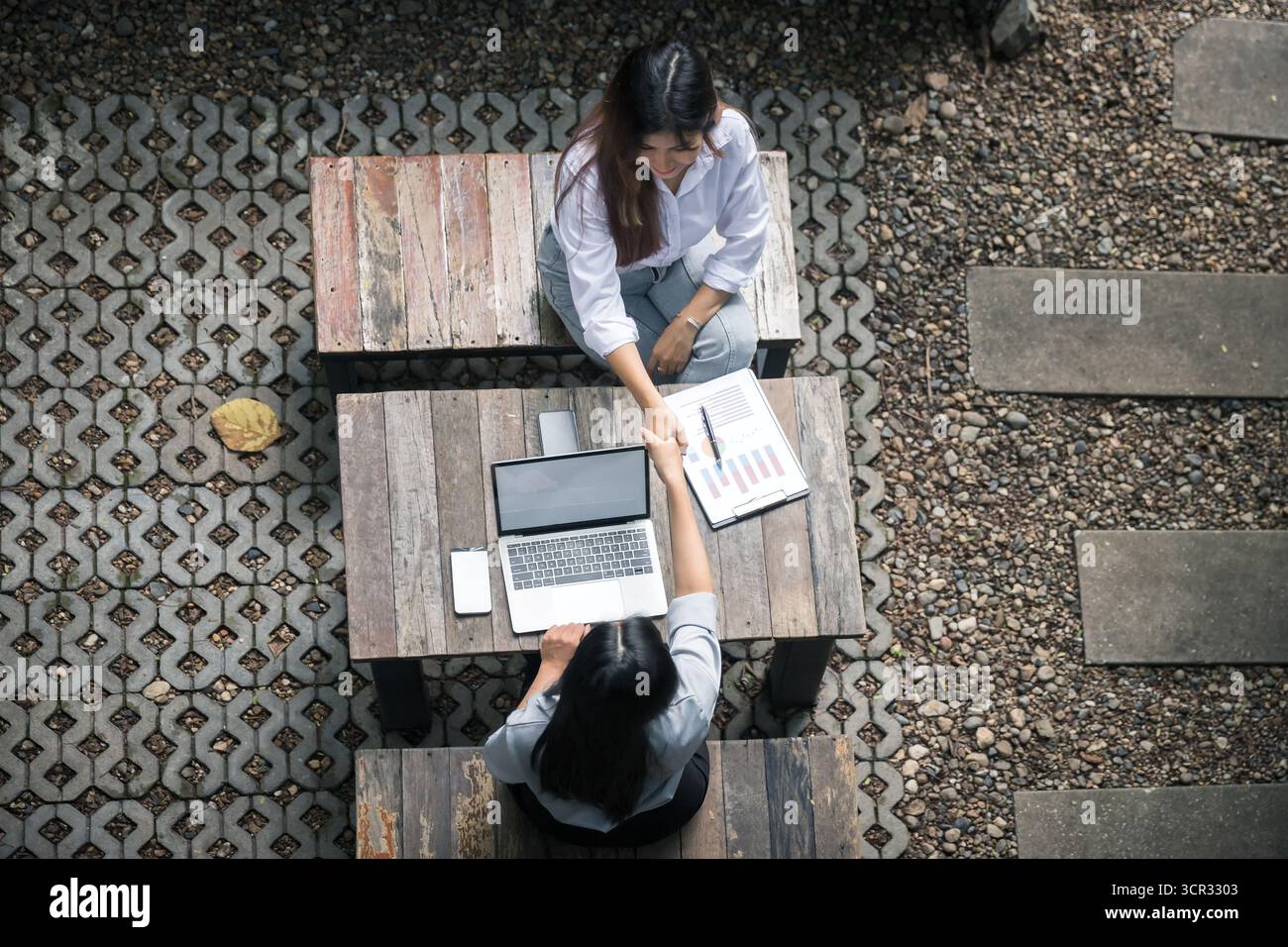 Vue de dessus de deux femmes d'affaires serrant la main sur un bureau. Banque D'Images
