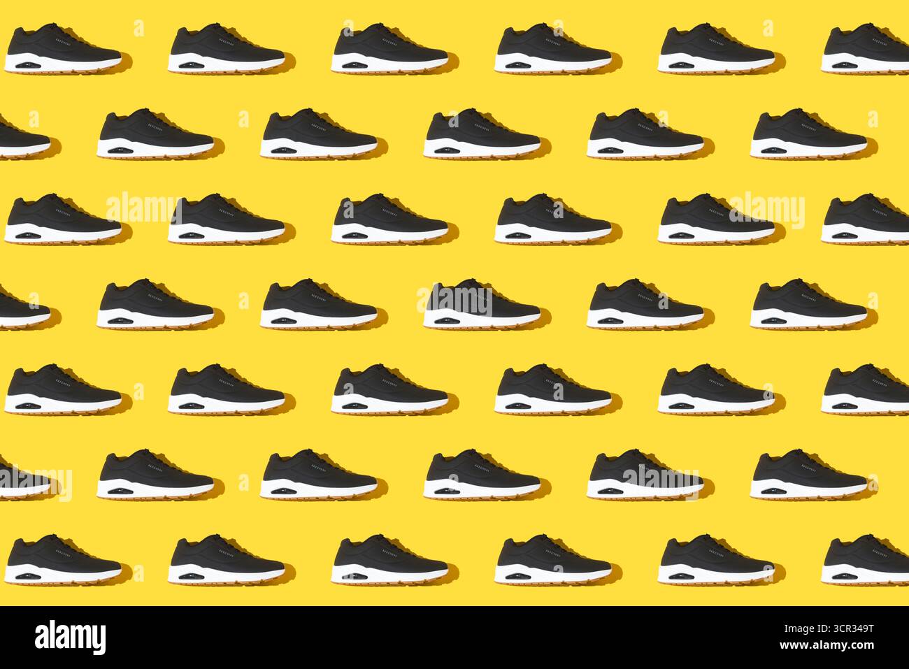 Motif de Skechers Uno noir Stand on Air sneakers sur fond jaune. Sportif, confortable, chambre à air, marche et décontracté. Banque D'Images