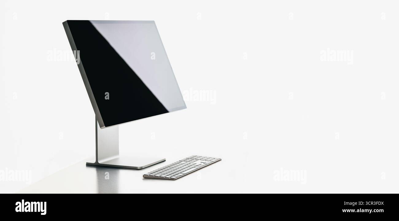 Ordinateur de bureau minimaliste au design élégant, écran vierge et clavier, isolé sur fond blanc. Idéal pour les maquettes d'espace de travail, technologie pr Banque D'Images