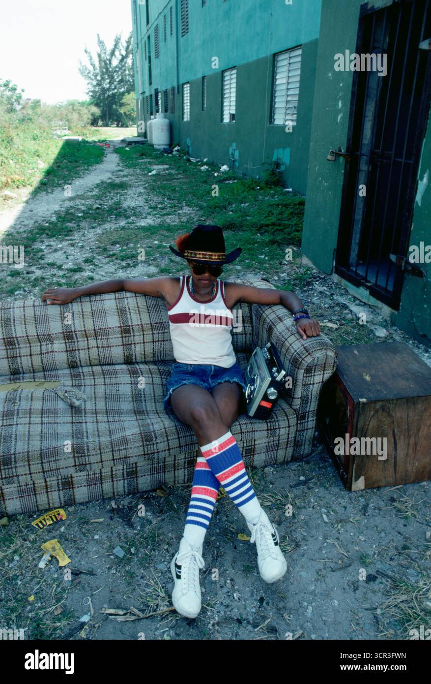 Jeune homme sur un canapé dehors, Miami, Floride. Banque D'Images