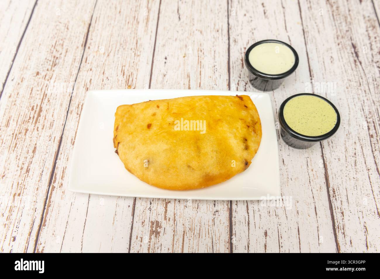 Empanadas au poulet et à l'avocat avec masa de maïs bleu, accompagné de salsa de mangue épicée et d'oignon rouge mariné Banque D'Images